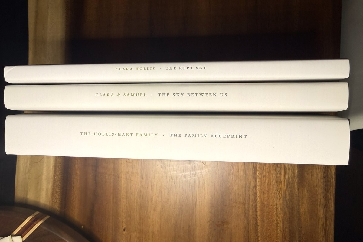 The three sample editions stacked spines out: The Kept Sky, The Sky Between Us and The Family Blueprint